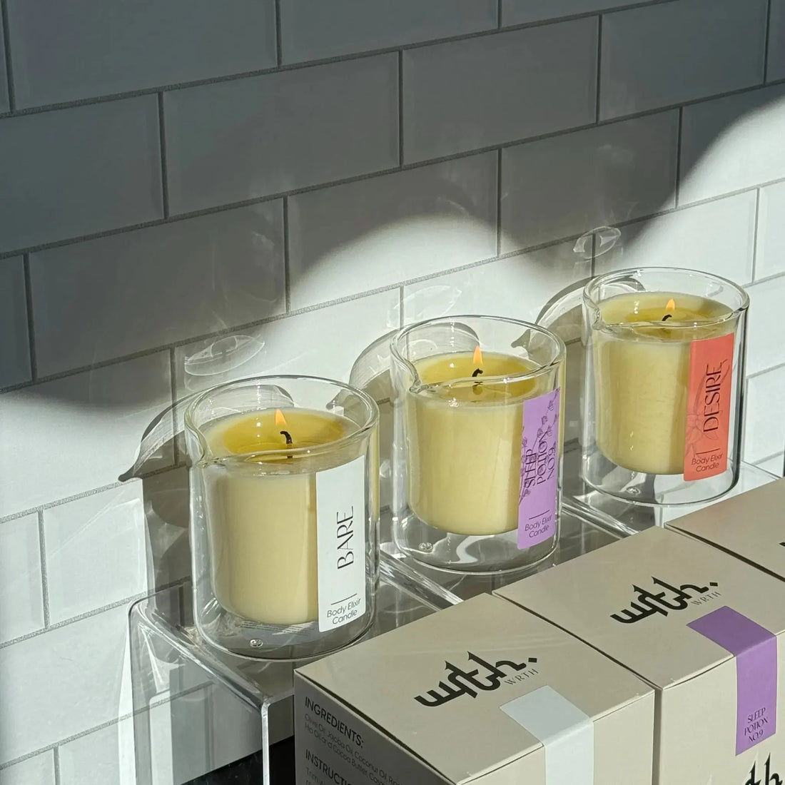 WRTH.STUDIO massage candles labeled Bare, Sleep Potion, Desire in glass containers with body elixir lotion packaging