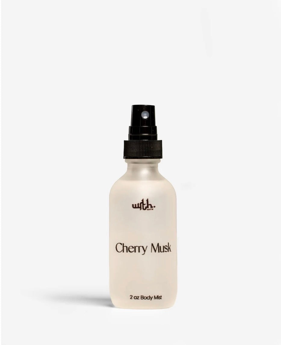 White bottle of Cherry Musk body mist with black cap on a white background