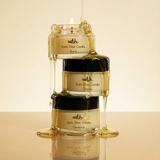 Three 'wrth.' body elixir candles stacked on a beige background