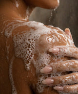 Person with soapy hands and body, focusing on the soap lather.