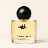 WRTH Tonka Suede Eau de Parfum, 1.7 oz clear glass bottle with pale golden perfume and a matte black spherical cap on a warm cream background
