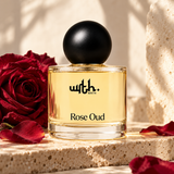 WRTH Rose Oud Eau de Parfum on a stone slab with a red rose and scattered petals