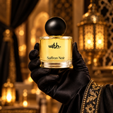 Black satin-gloved hand holding WRTH Saffron Noir Eau de Parfum against a warm backdrop with golden lanterns