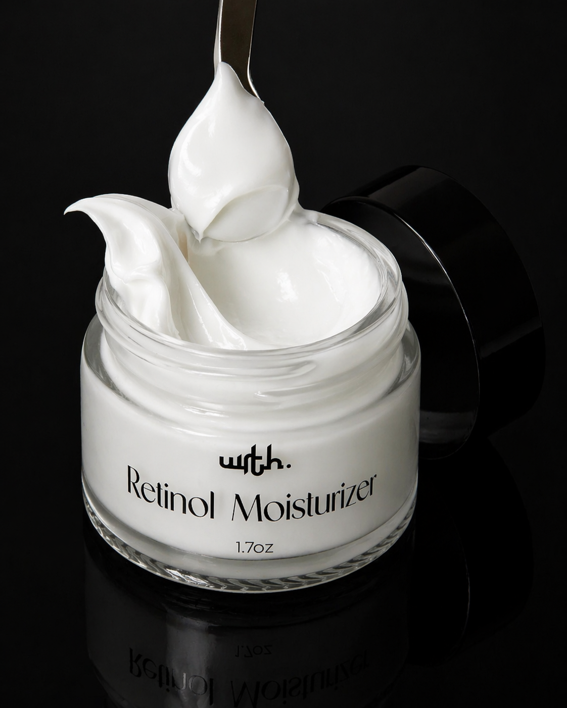 Jar of retinol moisturizer with a spoonful of cream on a black background