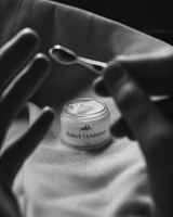 Jar of Retinol Moisturizer with a spoon on a textured surface
