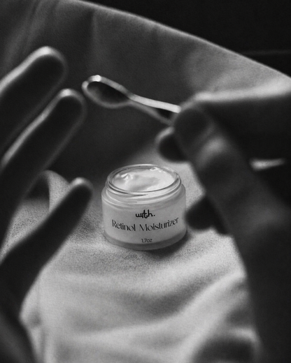 Jar of Retinol Moisturizer with a spoon on a textured surface