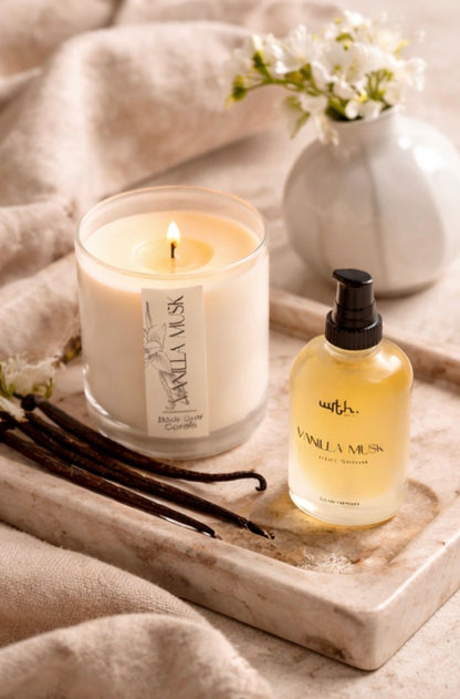 Candle and bottle with vanilla beans on a tray