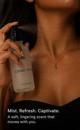 Person holding a Cherry Muse body mist with product details on a dark background