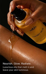 Hand applying cherry musk body oil to skin with visible brand text.