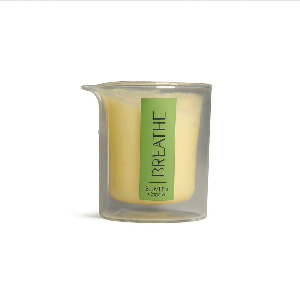 Clear glass candle labeled BREATHE with yellow wax inside, minimalist spa decor