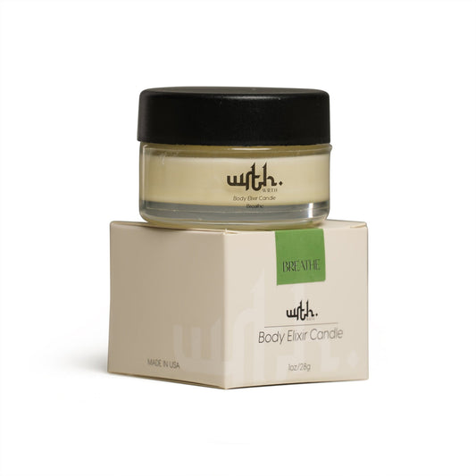 WRTH Studio Body Elixir Candle in glass jar with black lid, labeled 'Breathe,' on beige box