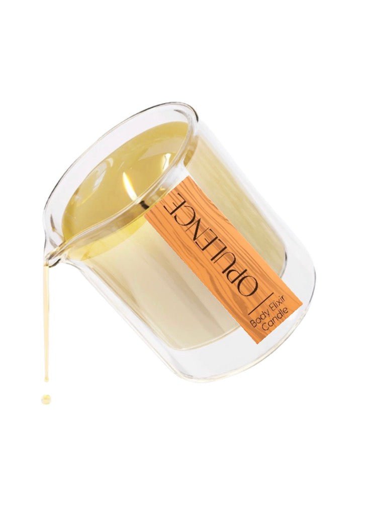 OPULENCE body elixir candle in glass container pouring warm golden liquid against white background
