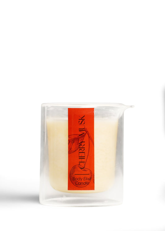 Cherry Musk Body Elixir Candle in clear glass container with orange label featuring cherry illustration